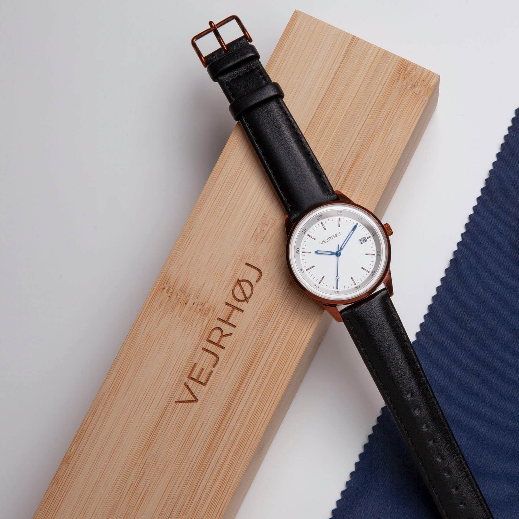 A06|VEJRHØJ's simple white dial and black leather strap Scandinavian design watch. It is placed in a special bamboo box.