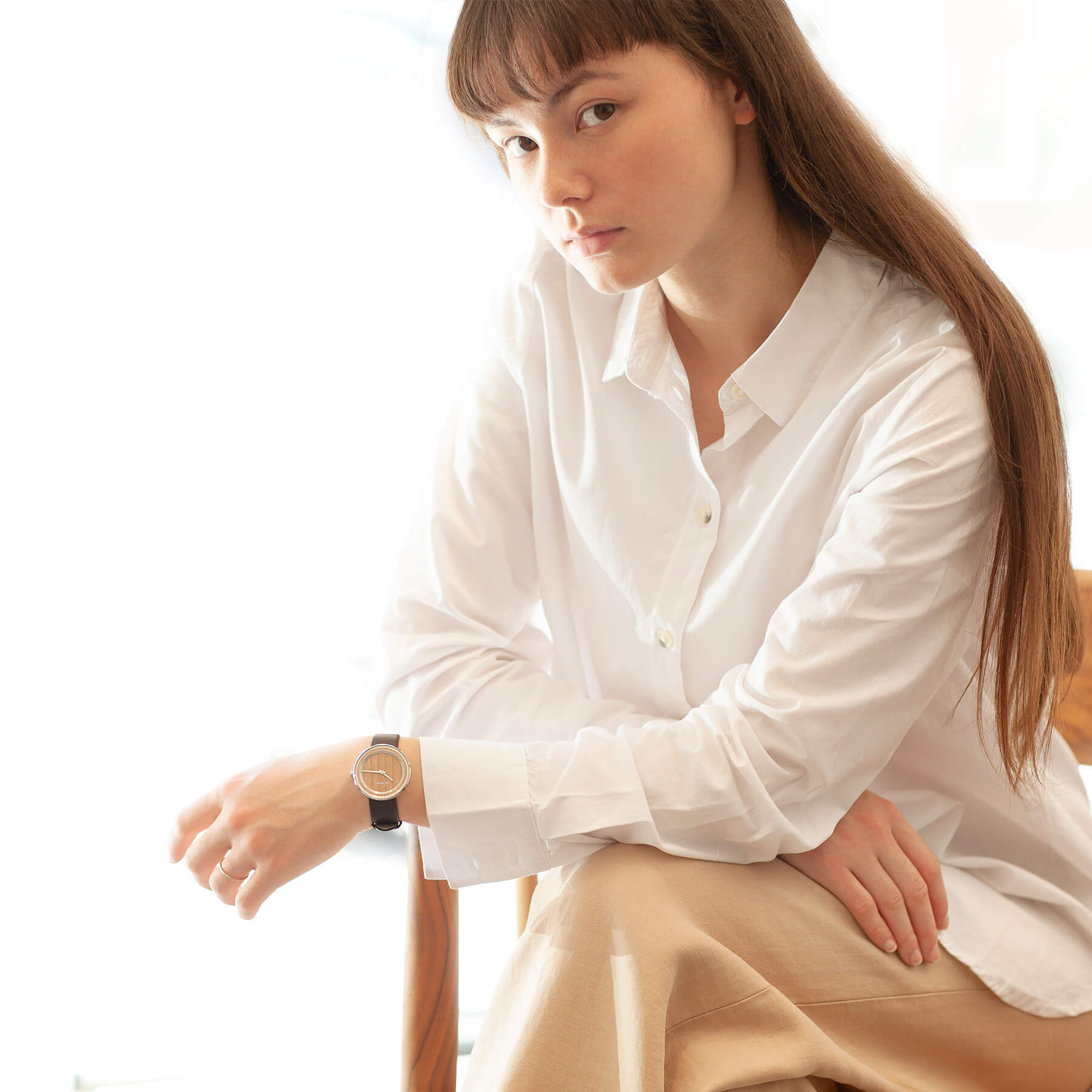 Young woman wearing a simple wooden watch with white shirt