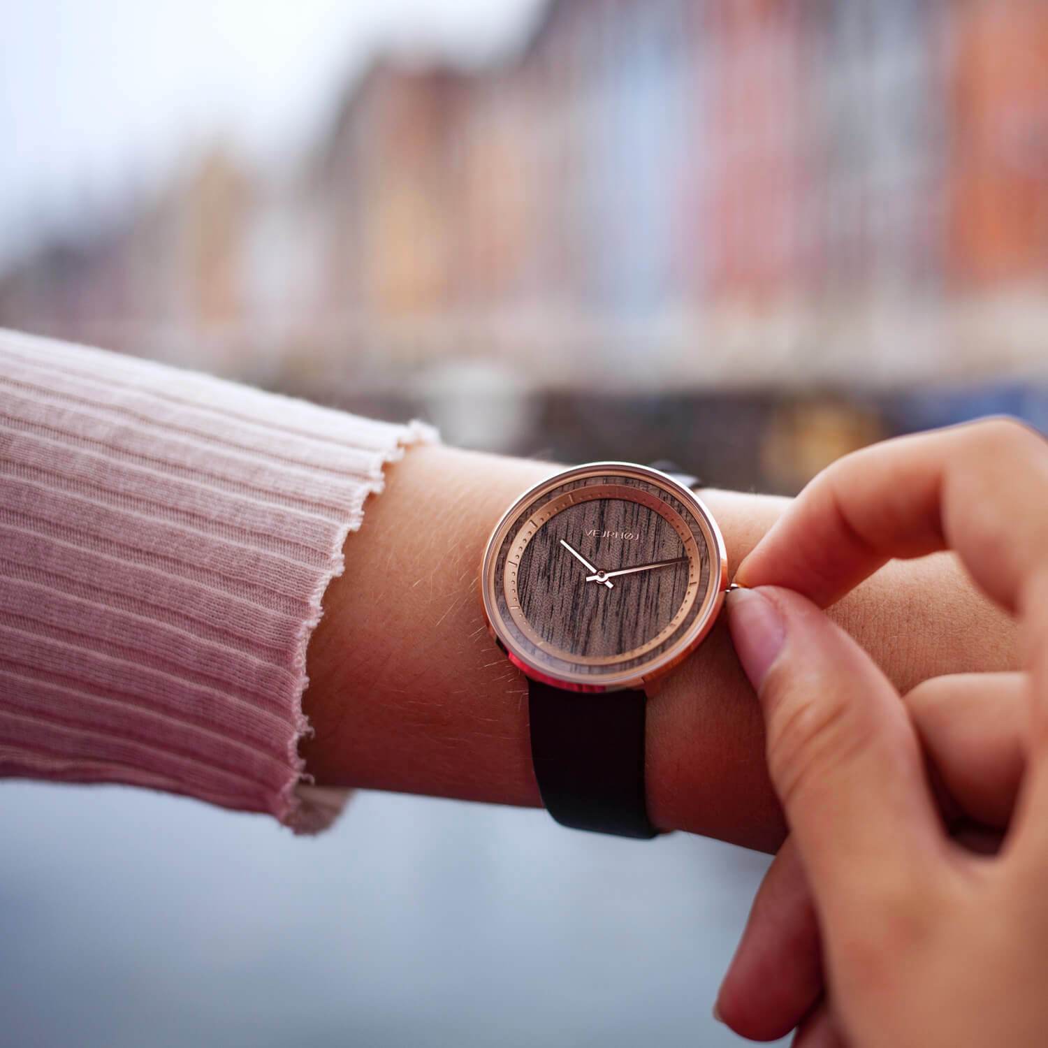 Hand with a wood watch for women in Nyhavn Copenhagen