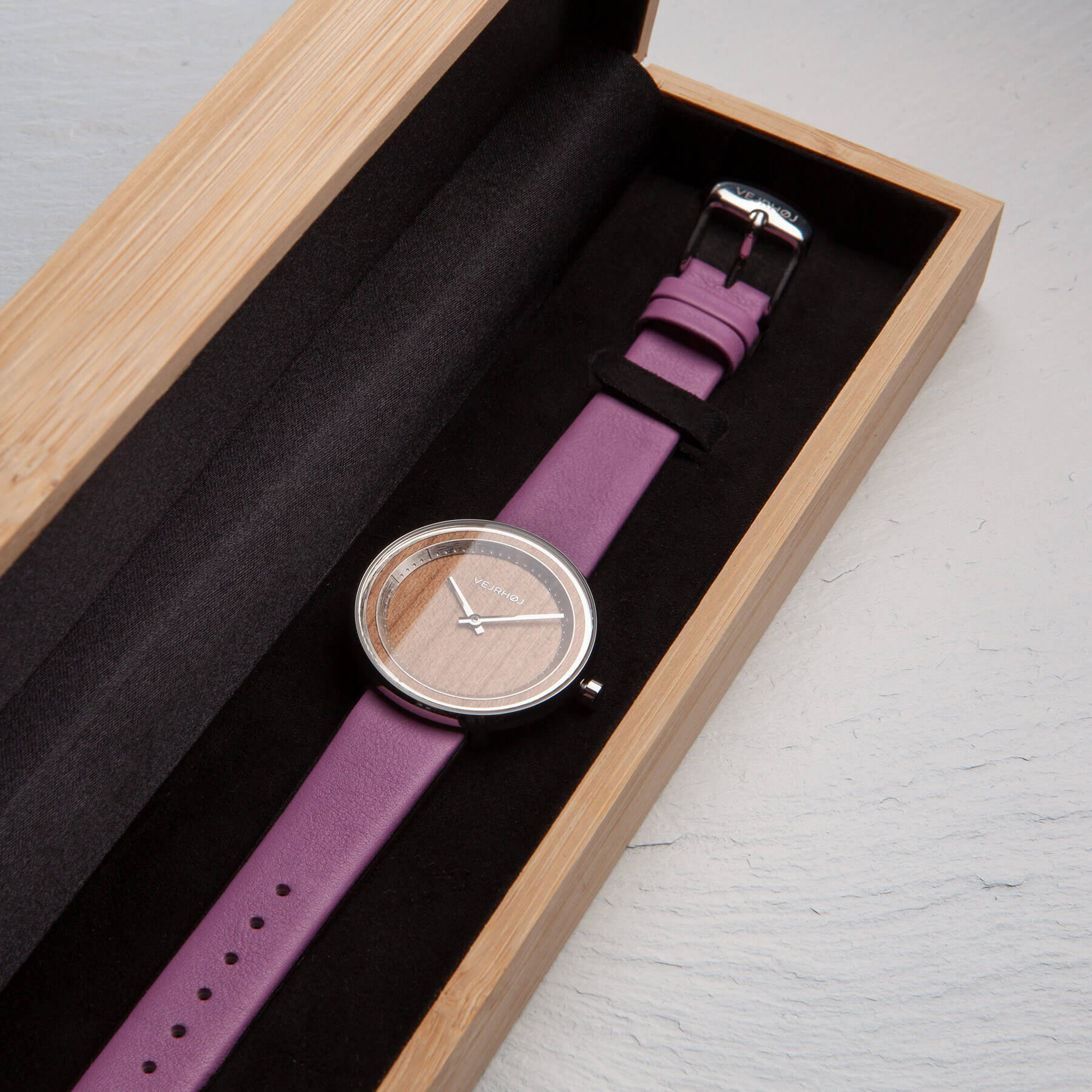 Wooden watch with steel casing and pink straps inside bamboo box