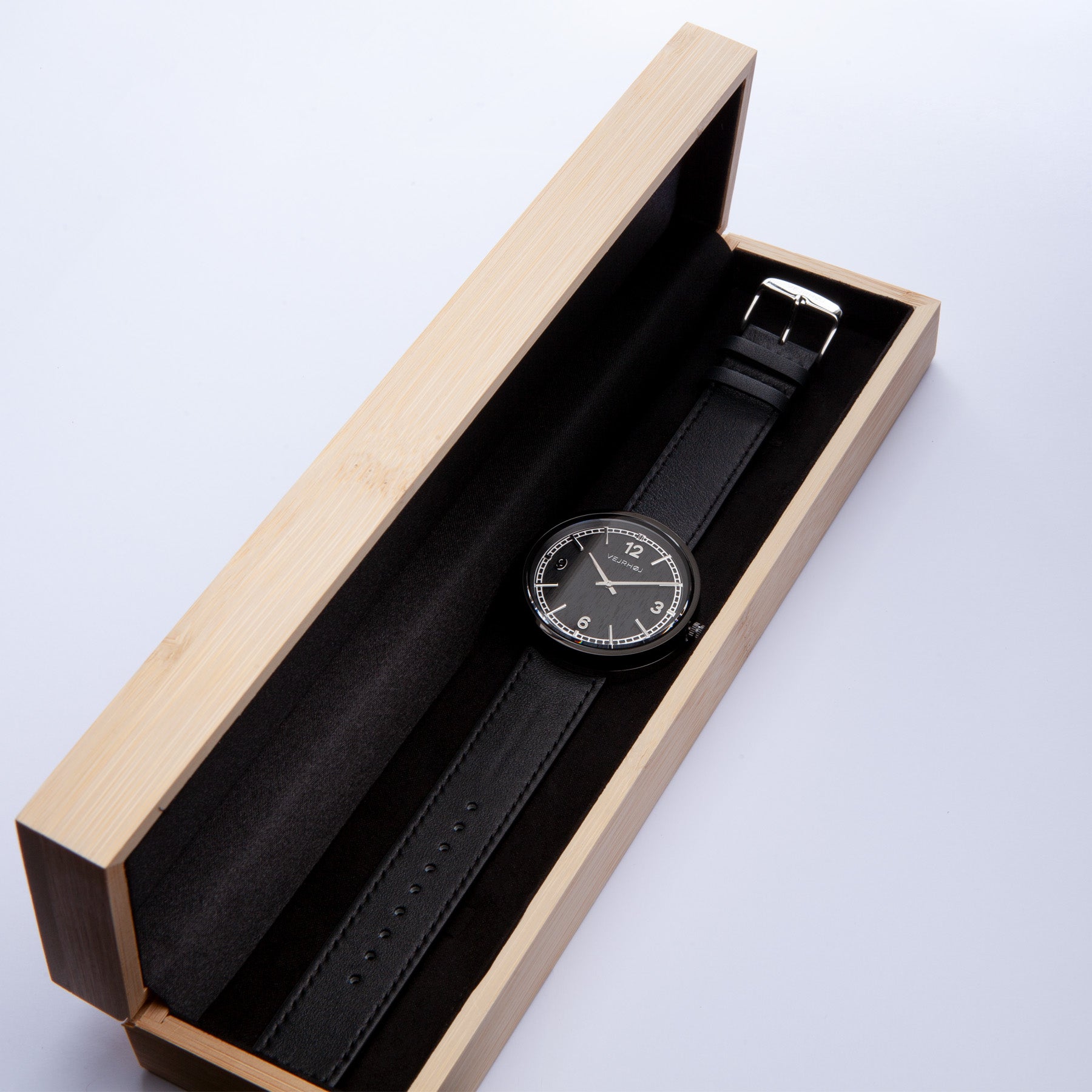 Black and silver wooden watch with numbers in wooden box