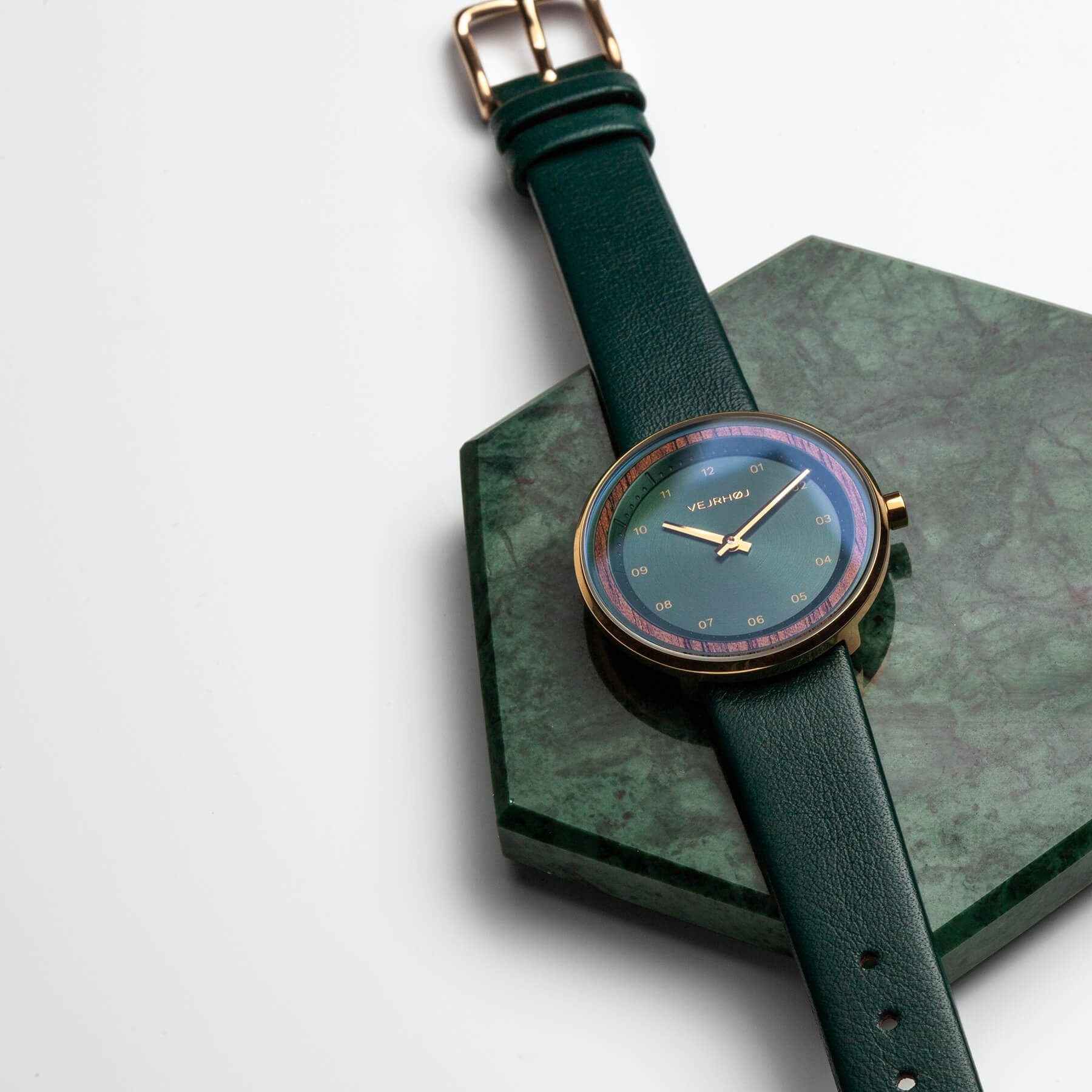 Green simplistic watch on green surface