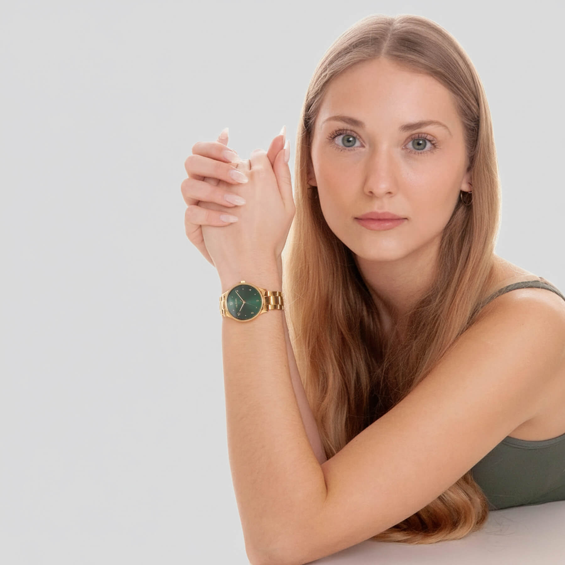 Woman wearing VEJRHØJ Petite Royal Green, ladies watch with gold bracelet and dark green circular finish dial