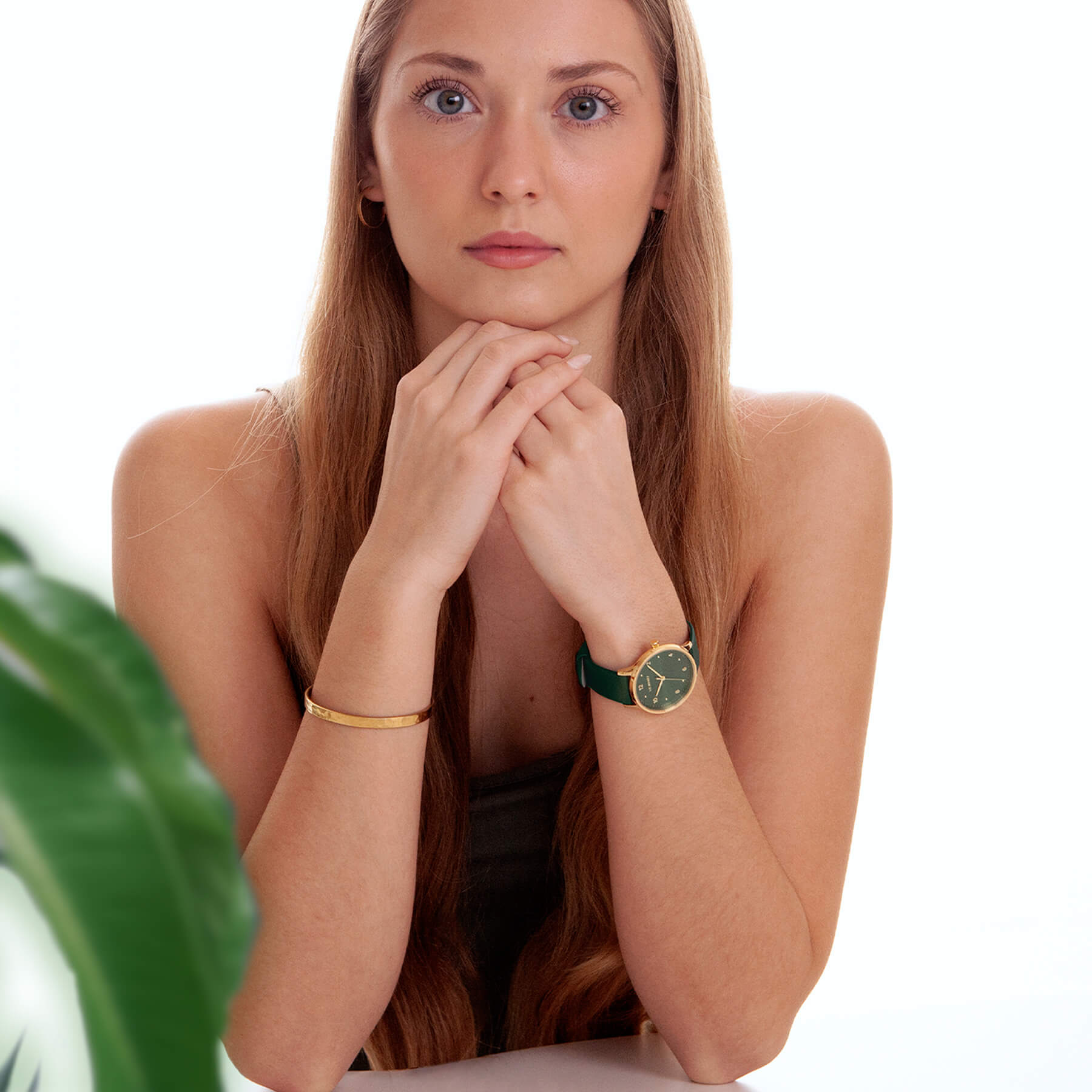 Woman wearing Vejrhøj's Petite Royal green watch with a gold bracelet.