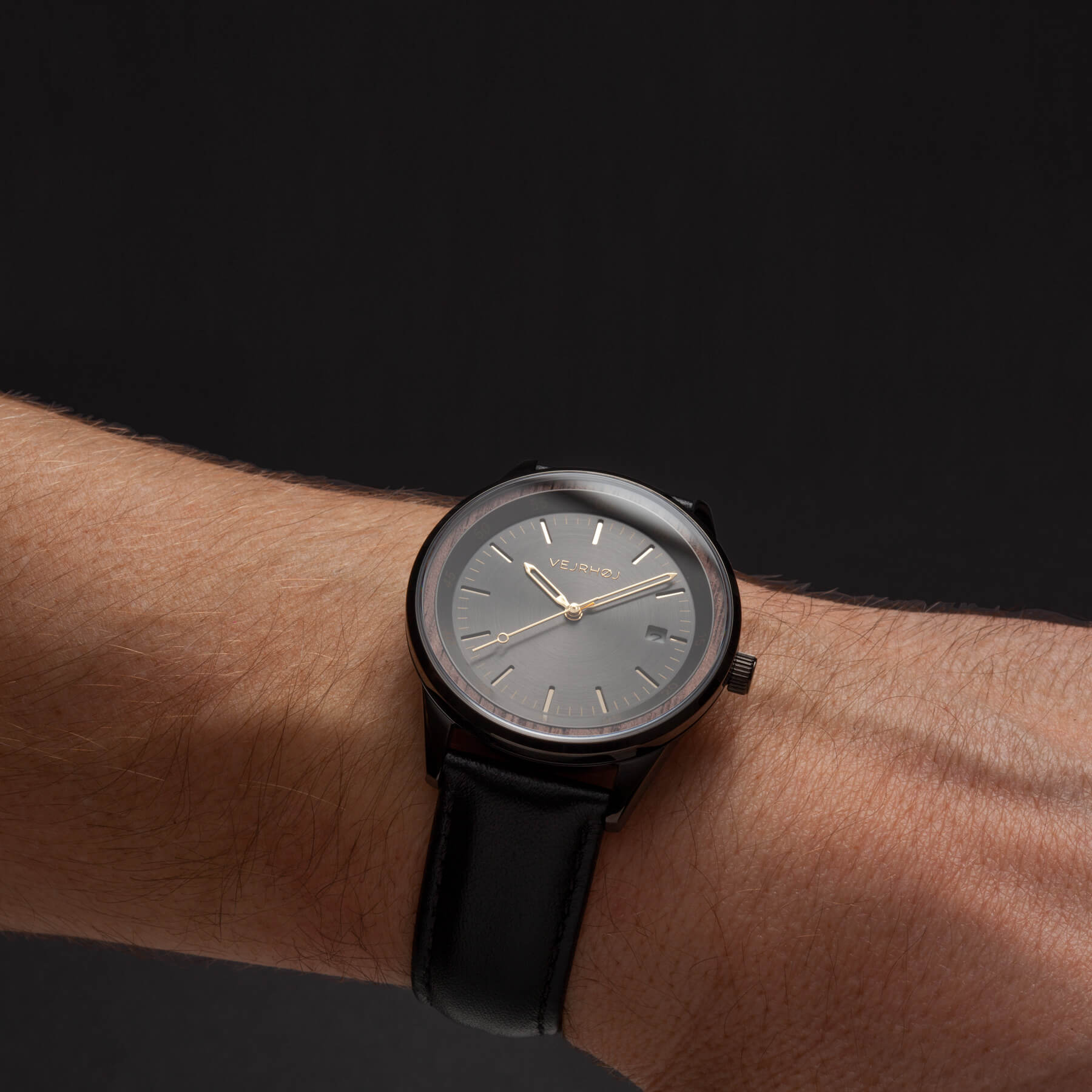 black automatic watch with black straps worn on a wrist
