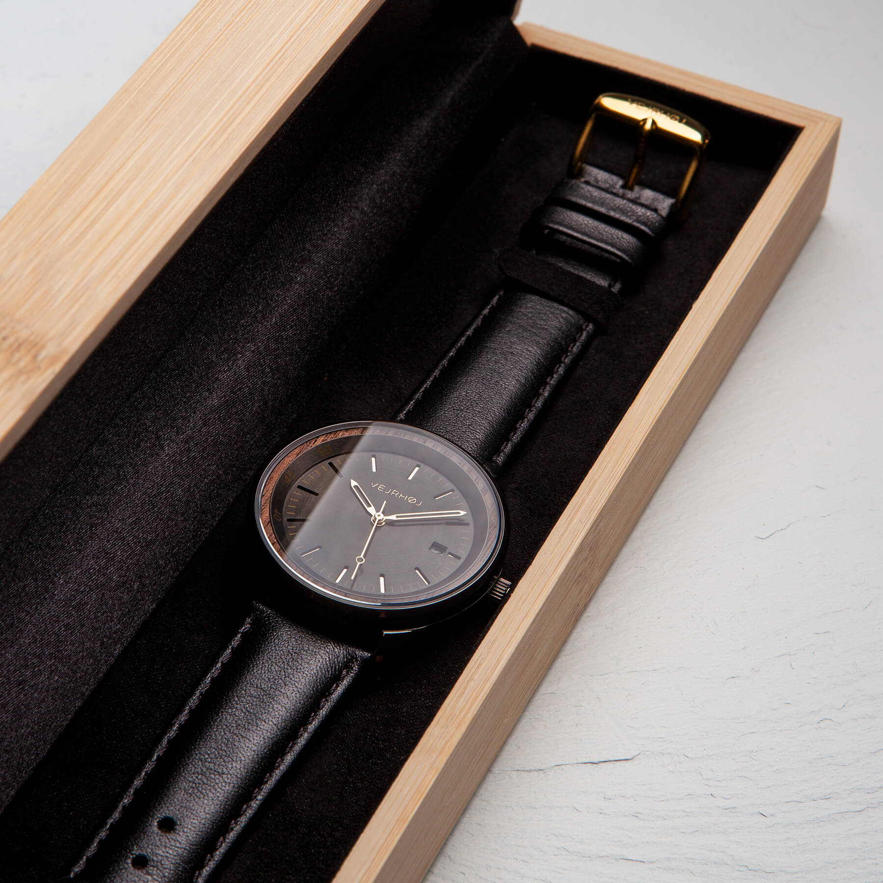 Black automatic watch inside a bamboo box