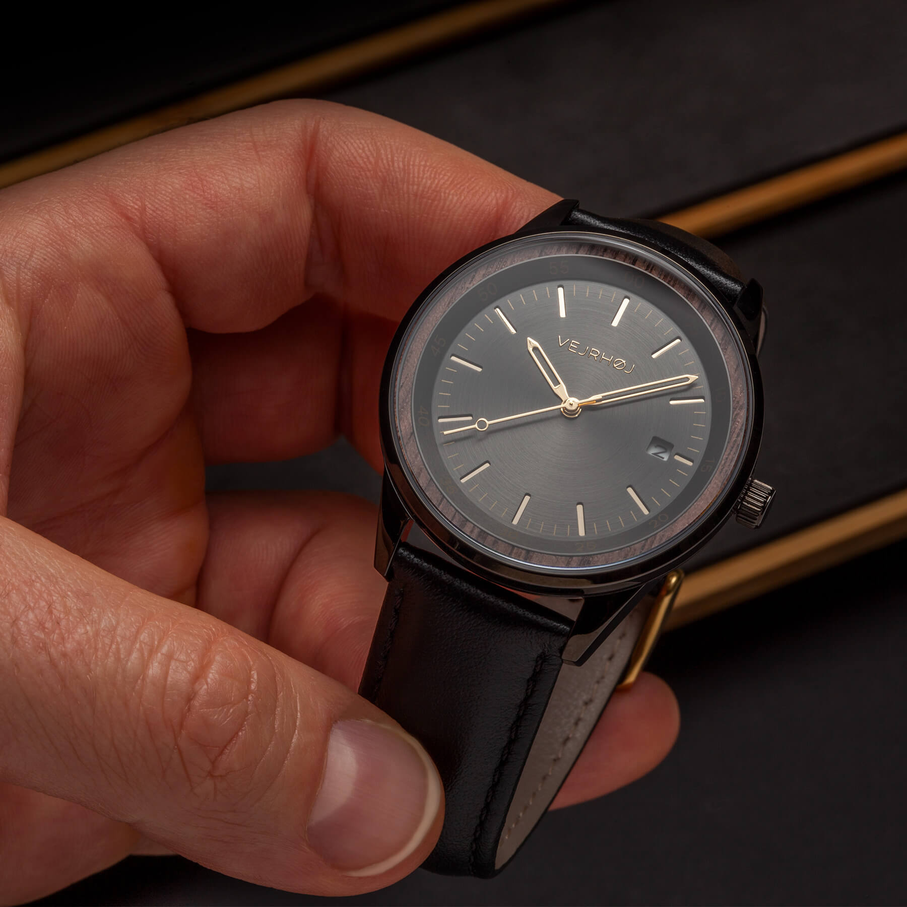 black automatic watch from Vejrhoj held by a hand