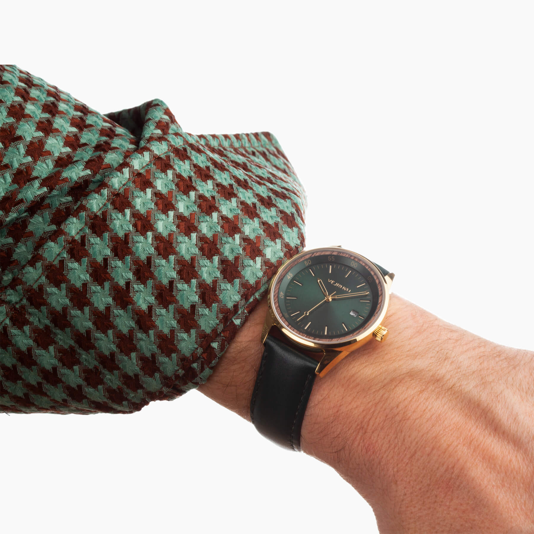 automatic wrist watch being worn with a green jacket resulting in a great pairing